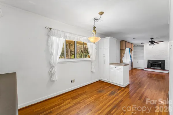 a view of empty room with wooden floor and fireplace