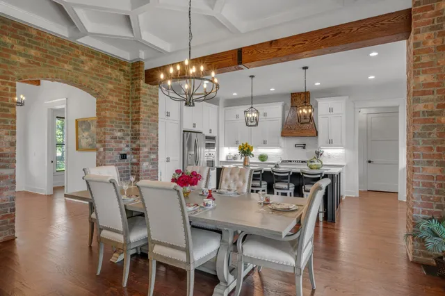 a kitchen with stainless steel appliances granite countertop a sink a stove and a wooden floors