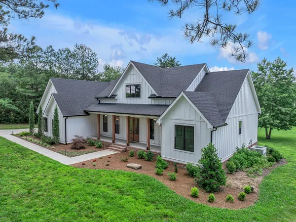 a front view of a house with swimming pool and porch with outdoor seating