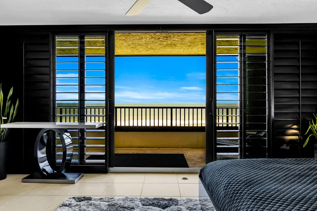 a bedroom with a bed and a large mirror on the dresser