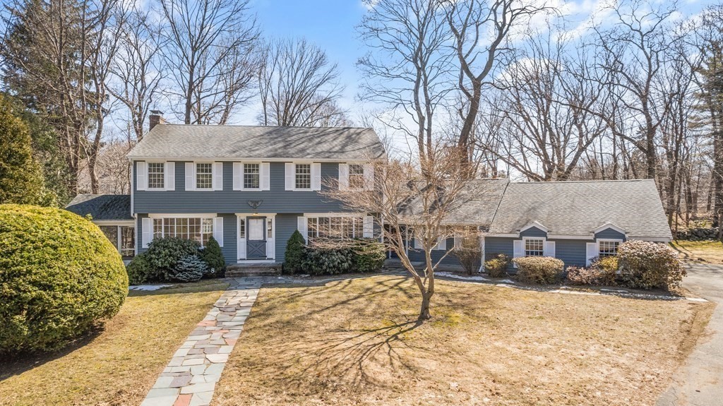 a front view of a house with a yard covered in snow