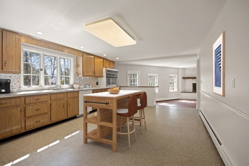 8 Juniper Place Lexington, MA 02420 - Photo 16 of 42 a kitchen with a table chairs refrigerator and cabinets