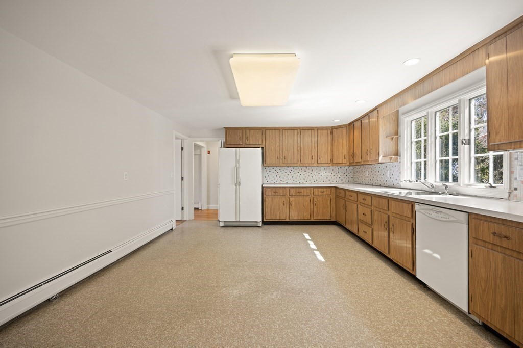 8 Juniper Place Lexington, MA 02420 - Photo 18 of 42 a view of a kitchen with a sink and dishwasher a refrigerator with white cabinets