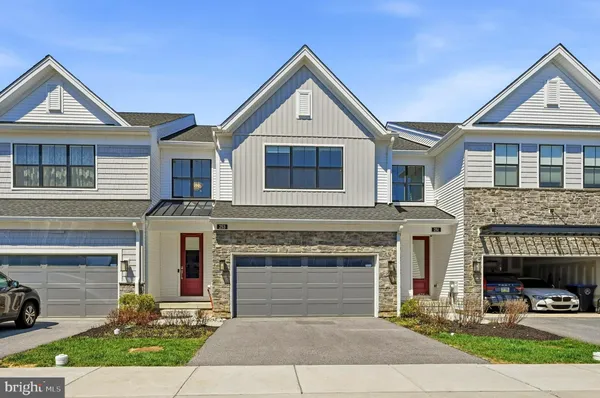 a front view of a house with yard and parking