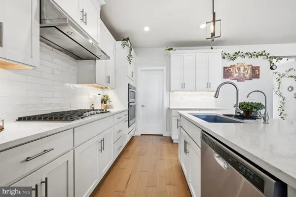 a kitchen with granite countertop a sink stove and cabinets