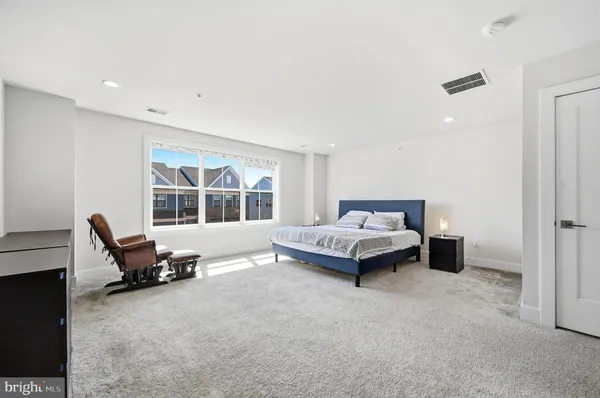 a spacious bedroom with a bed and a large window