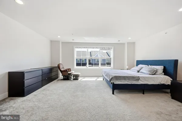 a bedroom with bed and a large window