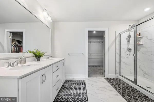 a bathroom with a double vanity sink and shower