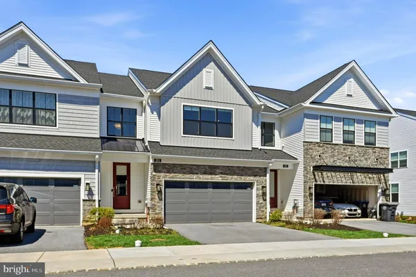 a front view of a house with garage and parking