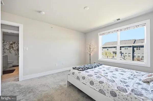a bedroom with a bed and a large window