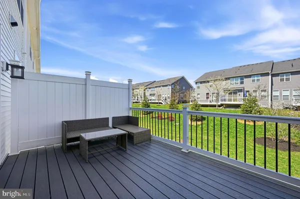 a view of a balcony with wooden floor and outdoor seating
