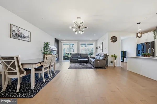 a living room with furniture a chandelier and a dining table