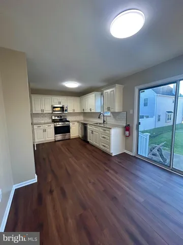 a kitchen with stainless steel appliances granite countertop a stove top oven a sink dishwasher and a refrigerator