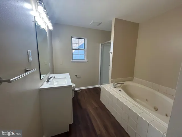 a bathroom with a tub sink and mirror