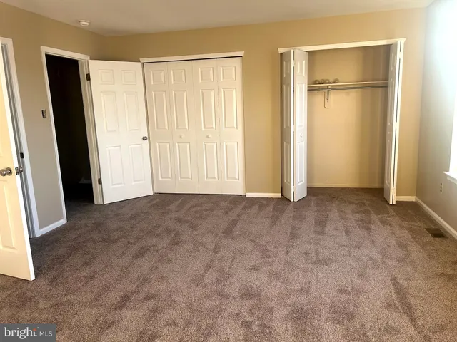 an empty room with closet and wooden floor