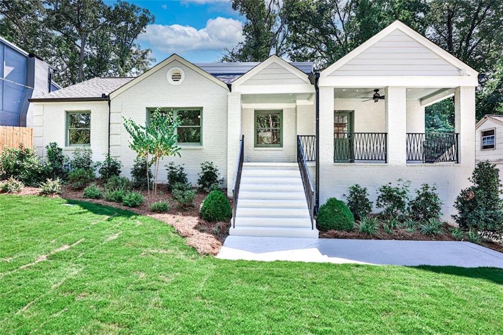 a front view of a house with a yard and potted plants