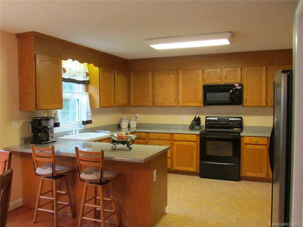 423 Maple Ridge Circle Salisbury, NC 28147 - Photo 8 of 21 a kitchen with stainless steel appliances granite countertop a stove a sink dishwasher and a microwave oven with wooden cabinets
