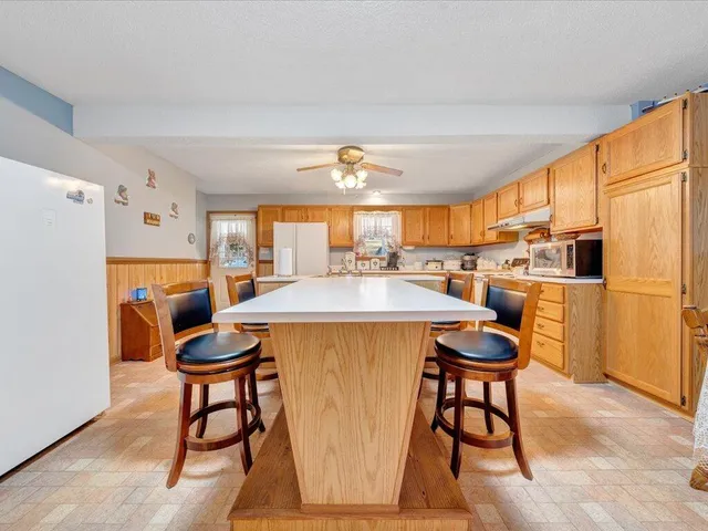 a kitchen with stainless steel appliances granite countertop a sink cabinets and wooden floor