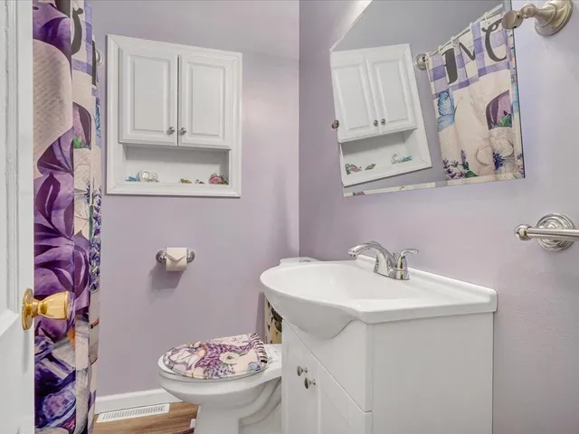 a bathroom with a granite countertop sink mirror vanity and toilet