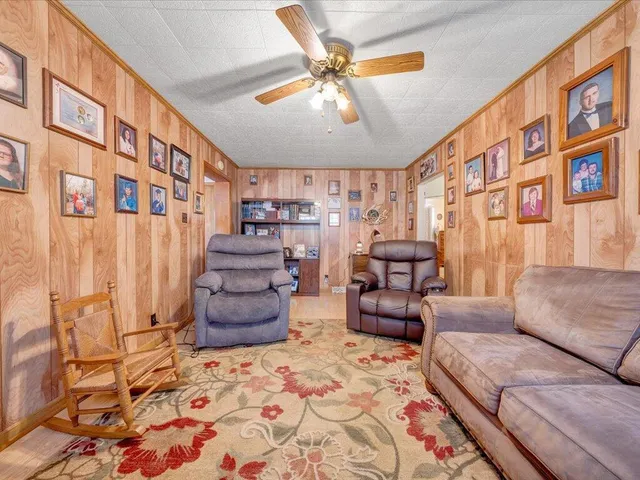 a dining hall with stainless steel appliances kitchen island granite countertop a table and chairs in it