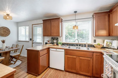 a kitchen with a sink stove cabinets and window