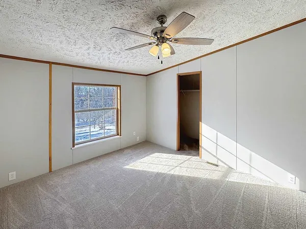 a view of an empty room with a ceiling fan
