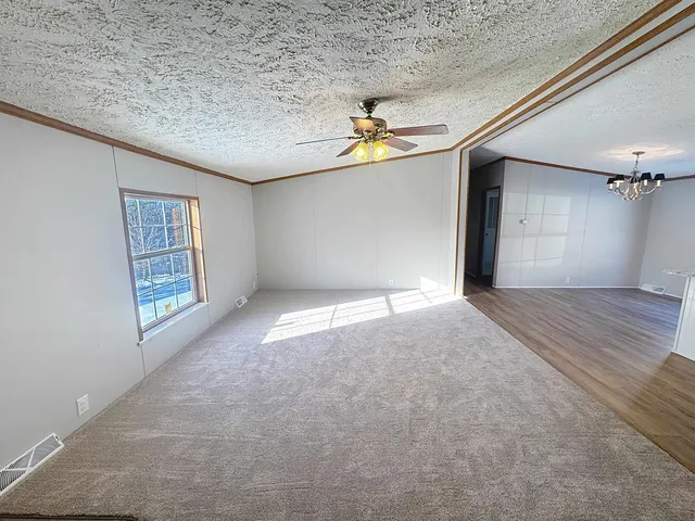 an empty room with windows and chandelier