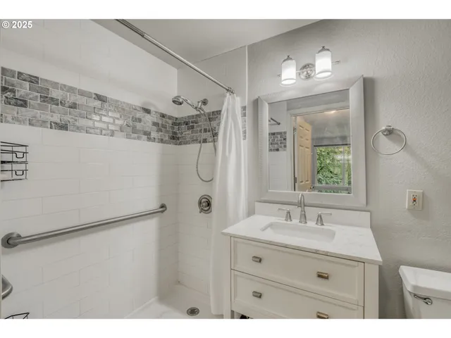 a bathroom with a sink mirror and a shower