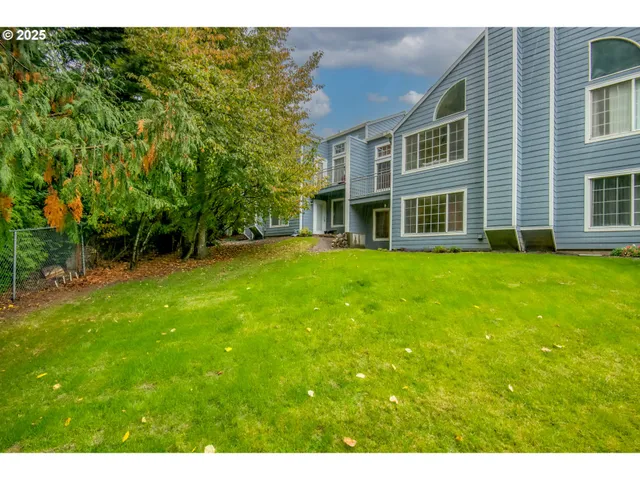 a view of a house with a big yard and large trees