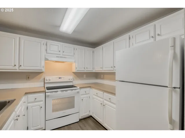 a kitchen with white cabinets and white appliances