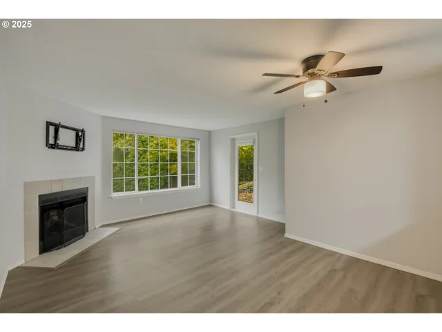 a view of an empty room with a fireplace and a window