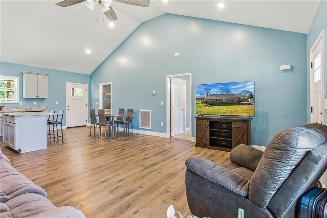 745 Dave Nix Road Seneca, SC 29678 - Photo 8 of 23 Voluminous vaulted ceilings elevate this open-concept great room, featuring rich hardwood-style flooring.