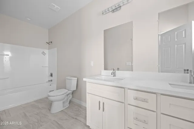 a spacious bathroom with a granite countertop sink a toilet and a mirror