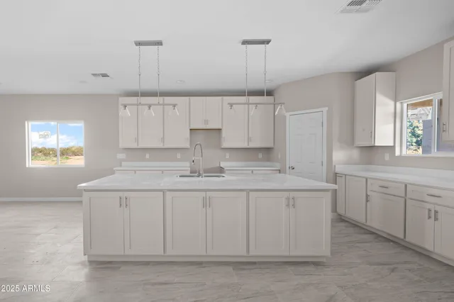 a kitchen with white cabinets and sink