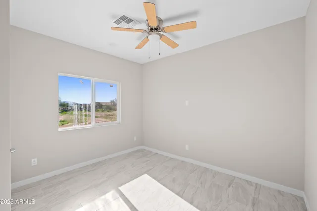 an empty room with a window and a fan