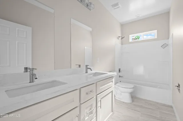 a bathroom with a double vanity sink toilet and shower