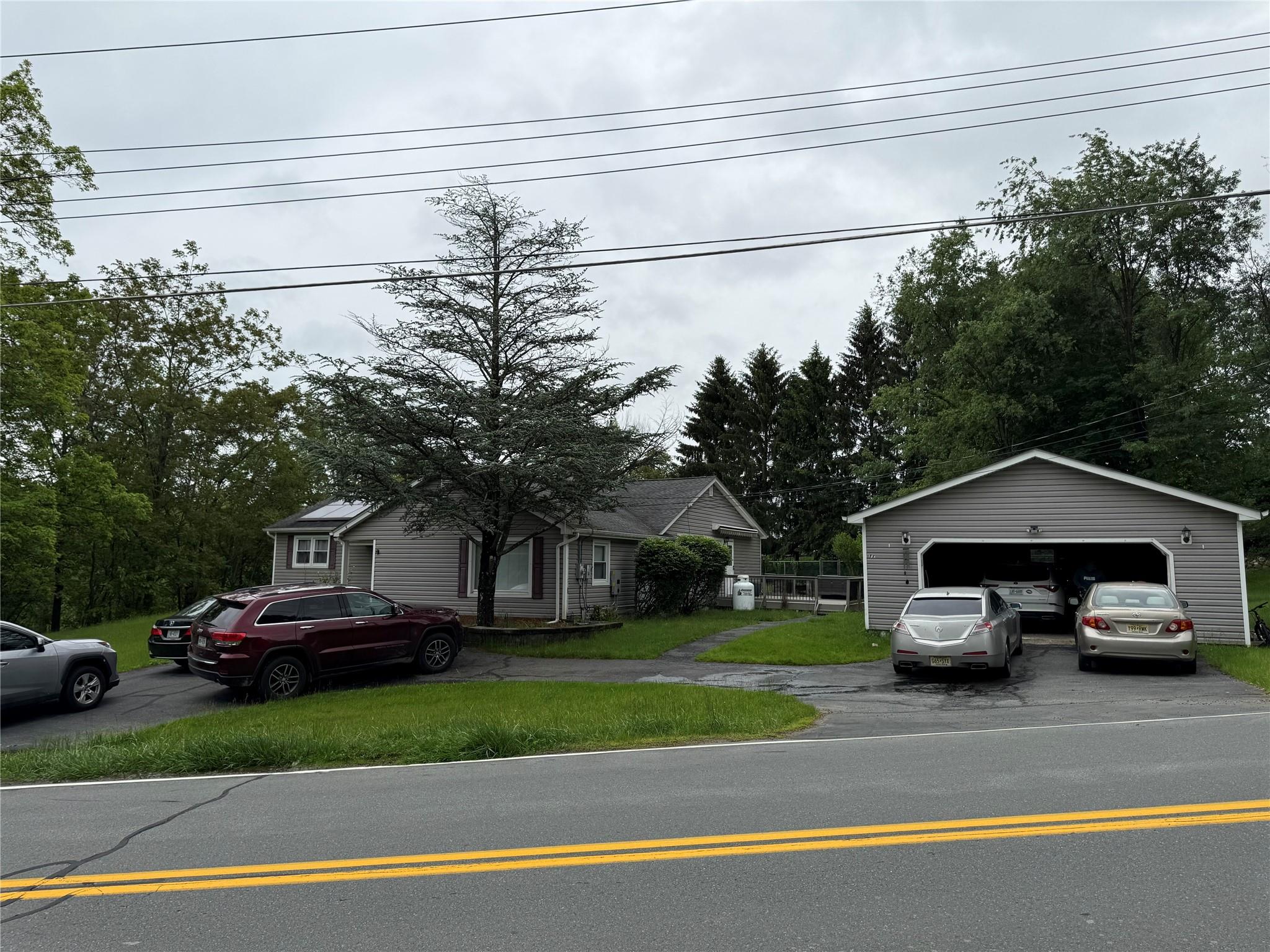 View of front of property featuring an outdoor structure and a garage