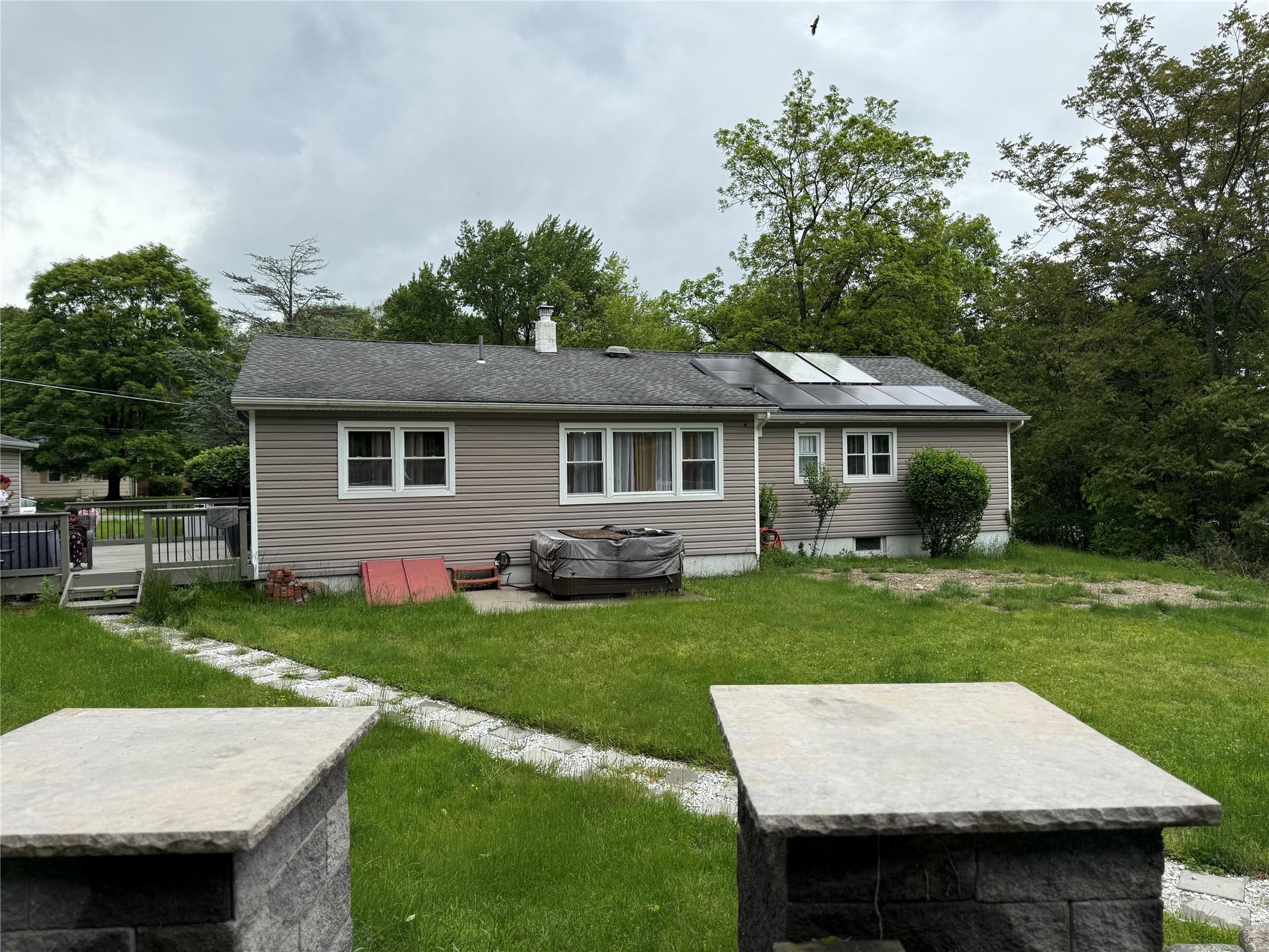 77 Upper Road Middletown, NY 10940 - Photo 18 of 18 Rear view of property with roof mounted solar panels, a yard, and a wooden deck