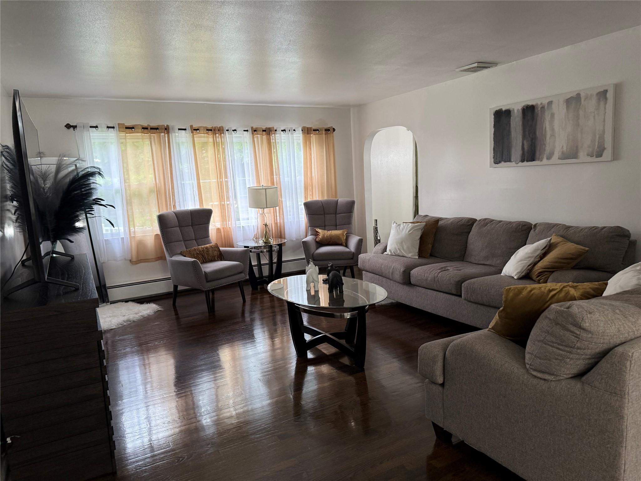 77 Upper Road Middletown, NY 10940 - Photo 2 of 18 Living room with arched walkways, a baseboard radiator, and dark wood finished floors