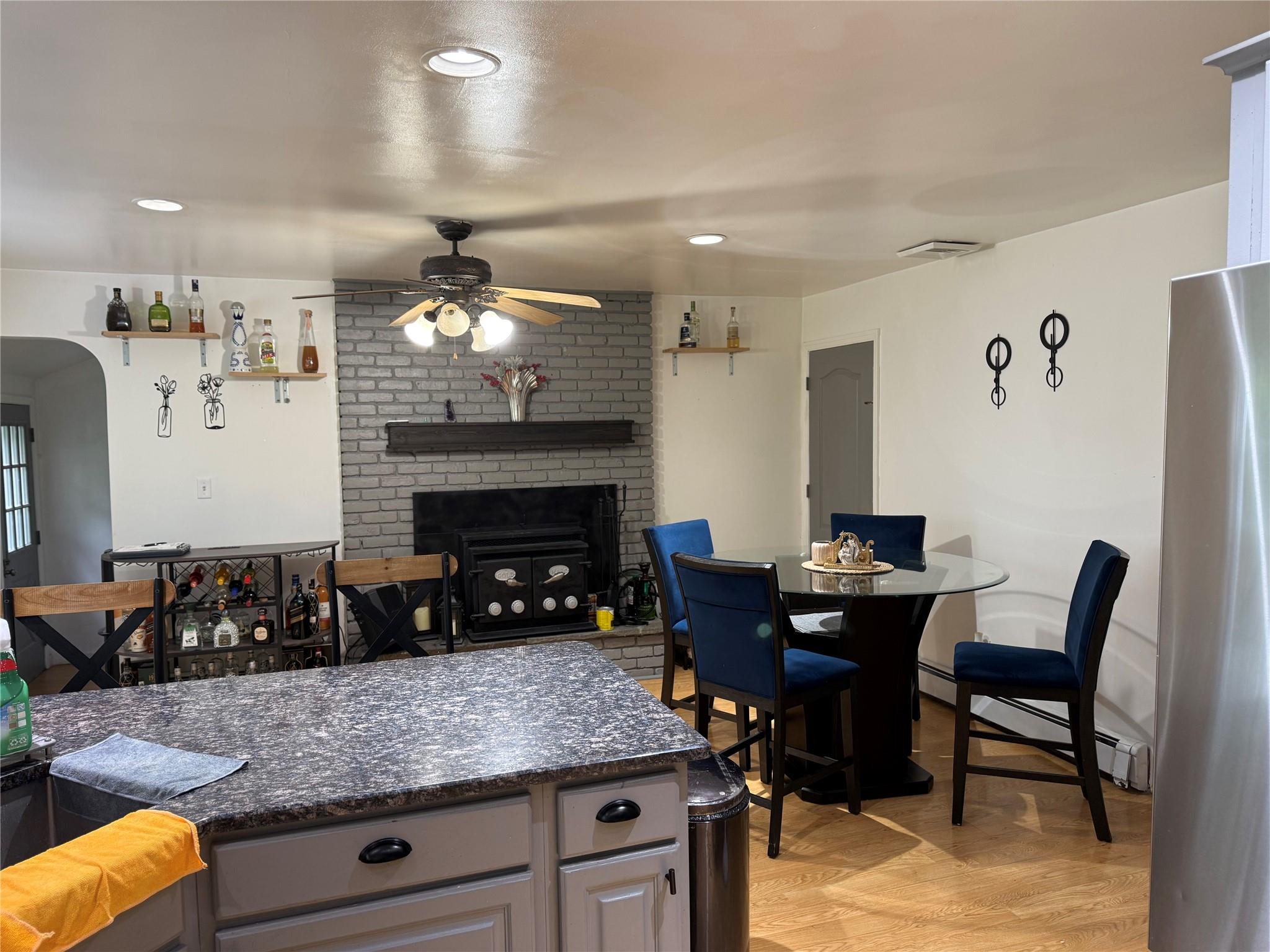 77 Upper Road Middletown, NY 10940 - Photo 5 of 18 Kitchen featuring ceiling fan, freestanding refrigerator, a brick fireplace, baseboard heating, and light wood-type flooring