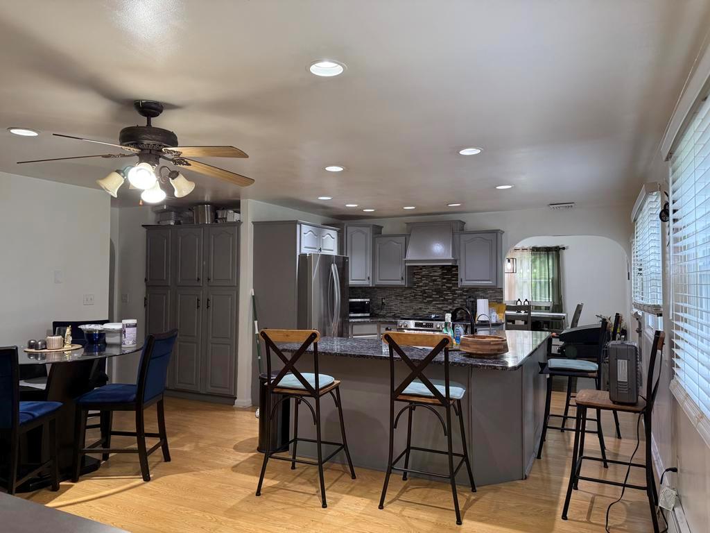 77 Upper Road Middletown, NY 10940 - Photo 6 of 18 Kitchen featuring freestanding refrigerator, a breakfast bar, wall chimney range hood, gray cabinets, and recessed lighting