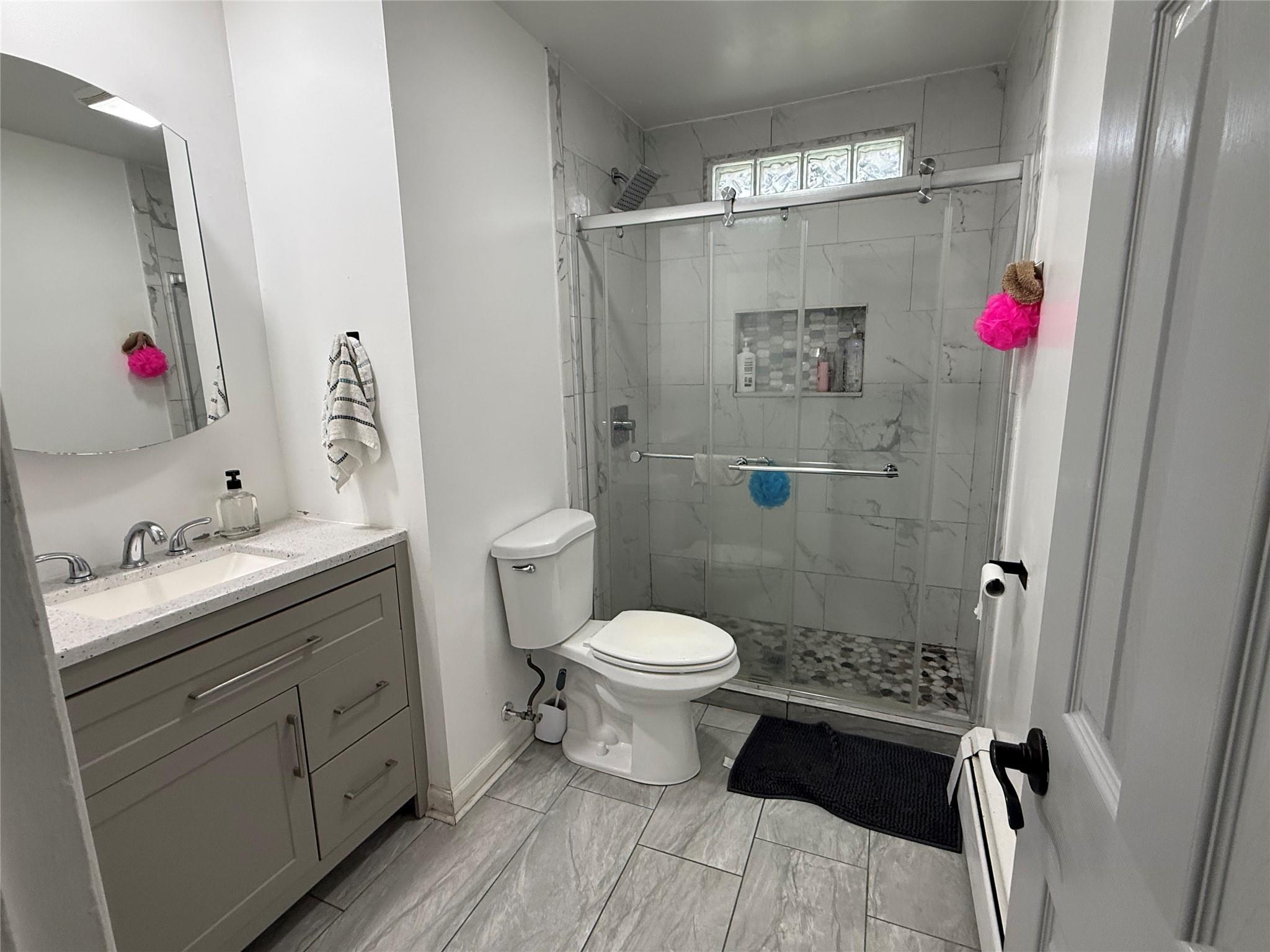 77 Upper Road Middletown, NY 10940 - Photo 10 of 18 Bathroom featuring toilet, a stall shower, vanity, and baseboards