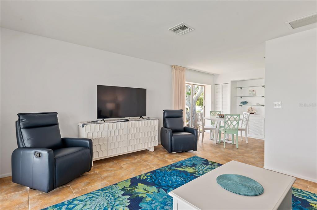 6005 Midnight Pass Road, Unit N13 Sarasota, FL 34242 - Photo 11 of 27 a living room with furniture and a flat screen tv