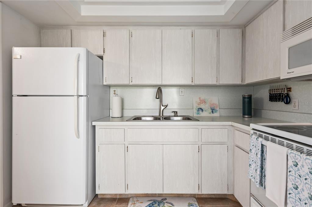 6005 Midnight Pass Road, Unit N13 Sarasota, FL 34242 - Photo 15 of 27 a white refrigerator freezer sitting inside of a kitchen