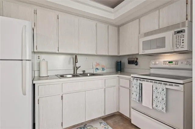 a kitchen with appliances a sink and cabinets
