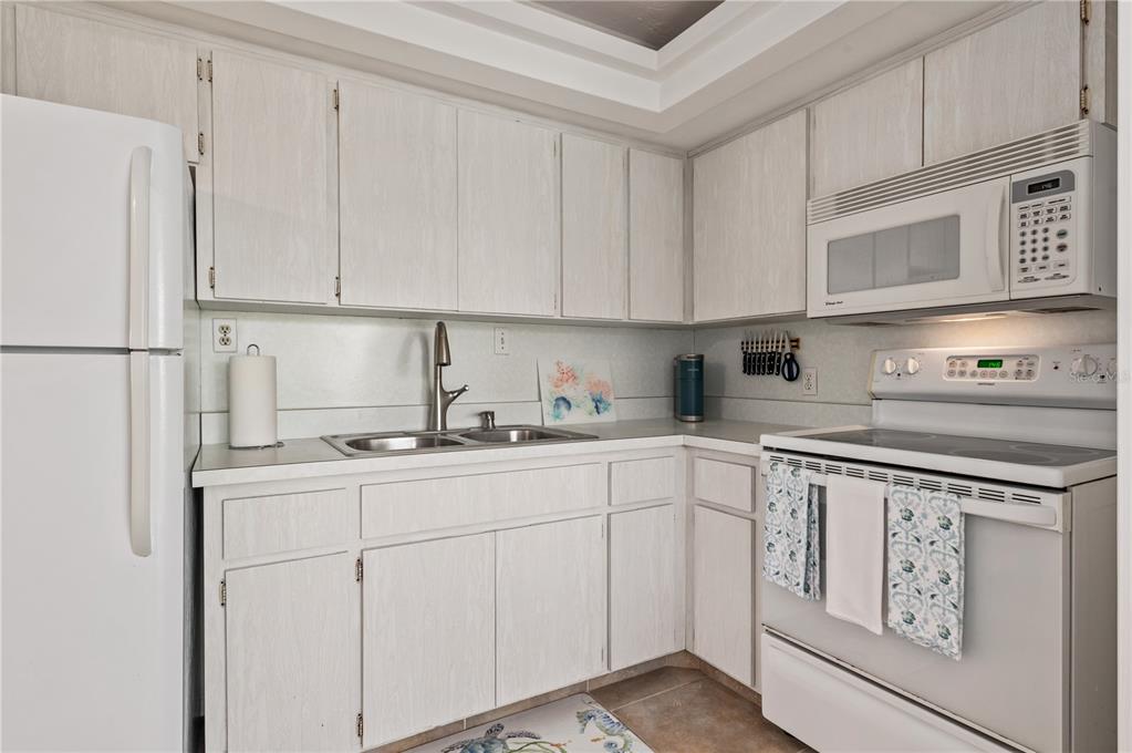 6005 Midnight Pass Road, Unit N13 Sarasota, FL 34242 - Photo 16 of 27 a kitchen with appliances a sink and cabinets
