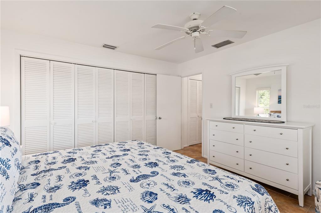 6005 Midnight Pass Road, Unit N13 Sarasota, FL 34242 - Photo 18 of 27 a bedroom with a bed and a mirror on dresser
