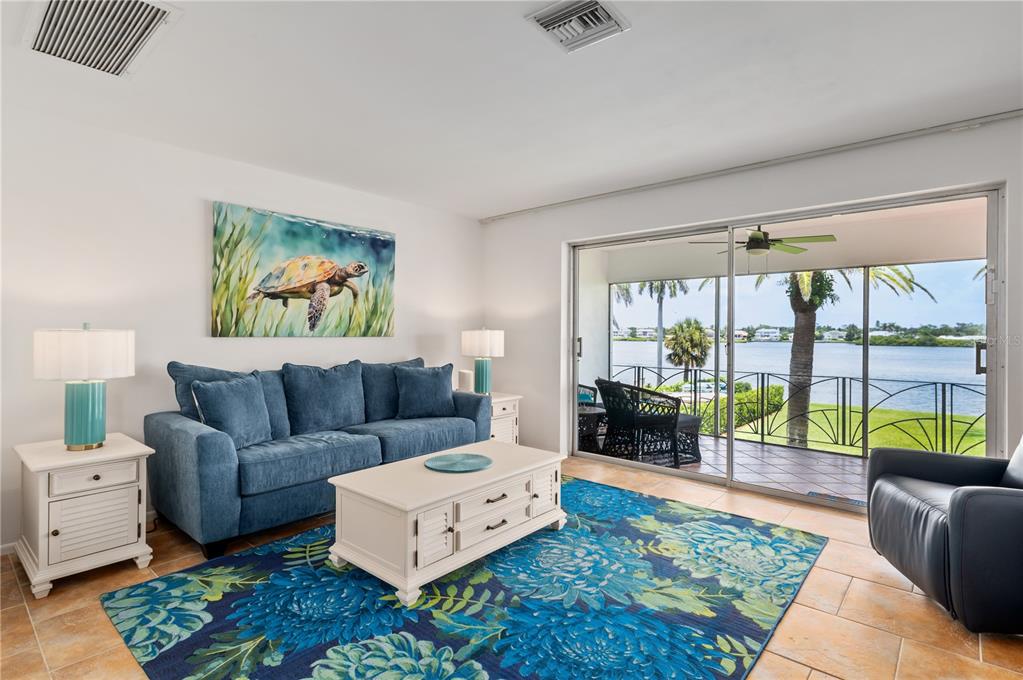 6005 Midnight Pass Road, Unit N13 Sarasota, FL 34242 - Photo 7 of 27 a living room with furniture and a floor to ceiling window