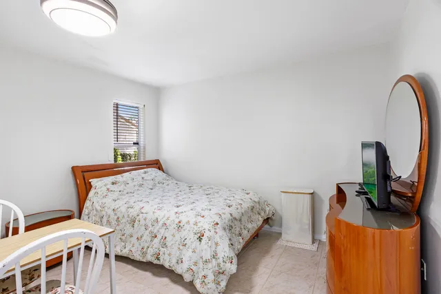 a bedroom with a bed a couch and a mirror on the dresser