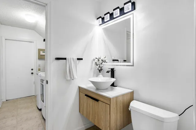 a bathroom with a sink toilet and mirror